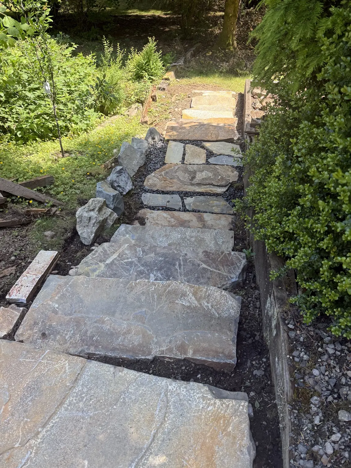 Natural stone stairway and landing taking shape on the hillside