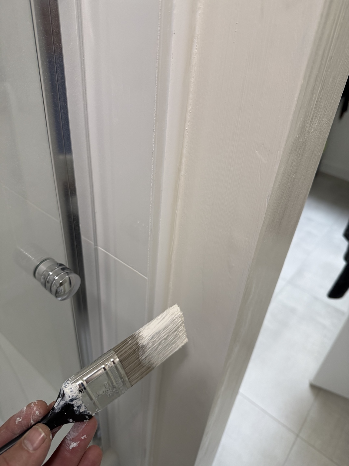 Priming and painting the repaired shower-side wall and PVC trim